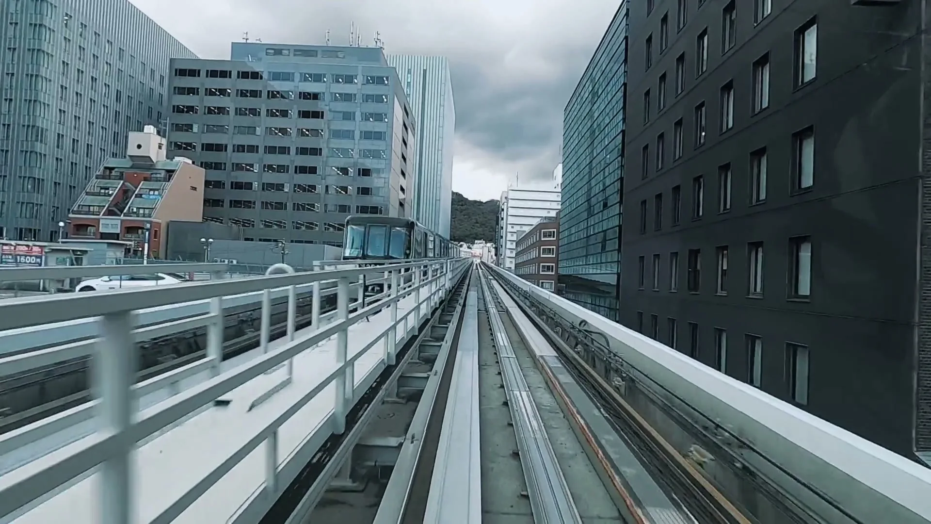 Illustrative view along an elevated rail corridor between city buildings